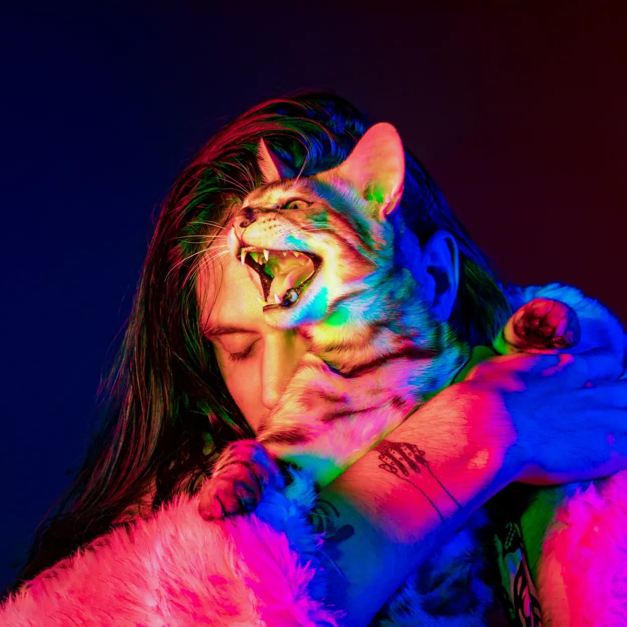 A person holding a cat, both washed in neon color