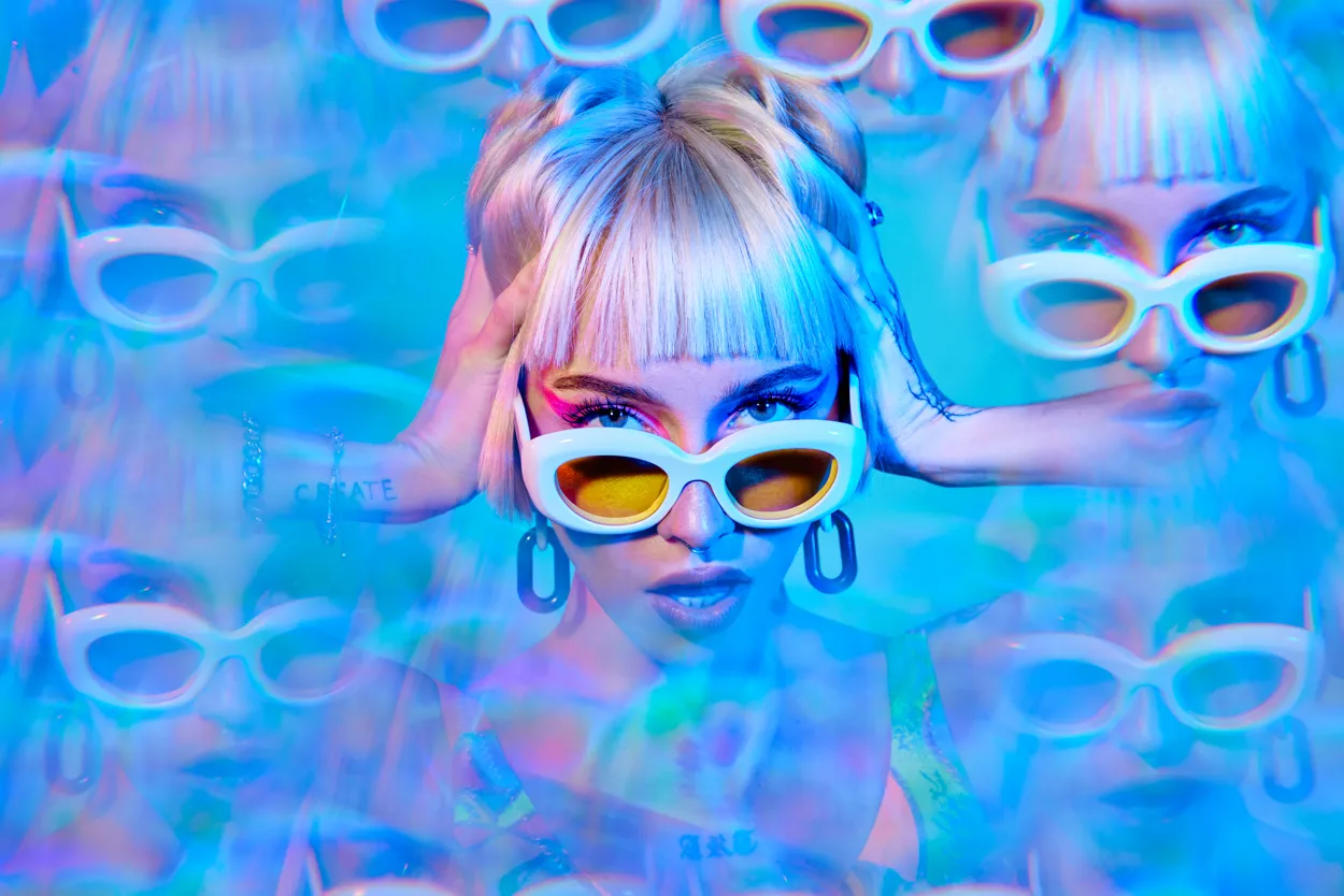 A woman in white sunglasses repeated across a blue multiple exposure